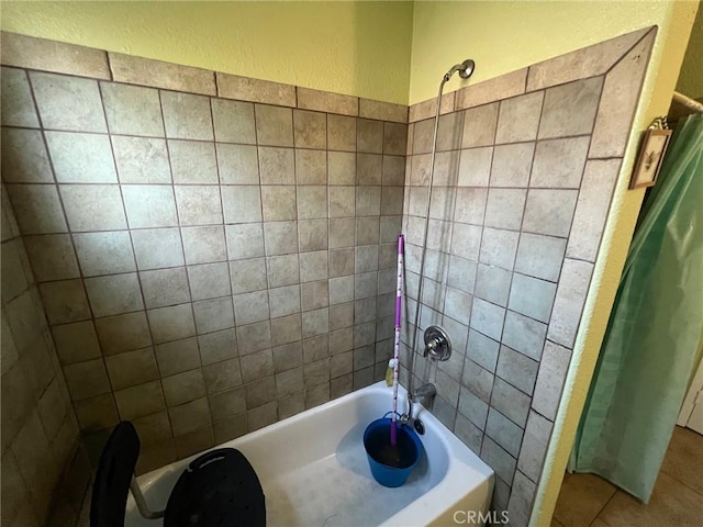 bathroom featuring tile patterned flooring and tiled shower / bath