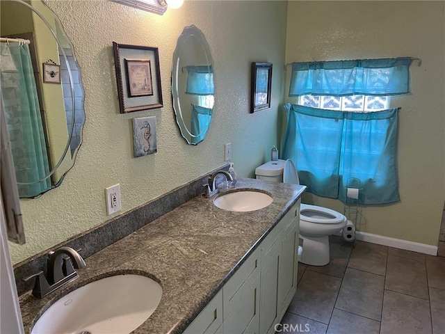 bathroom featuring tile patterned flooring, vanity, and toilet