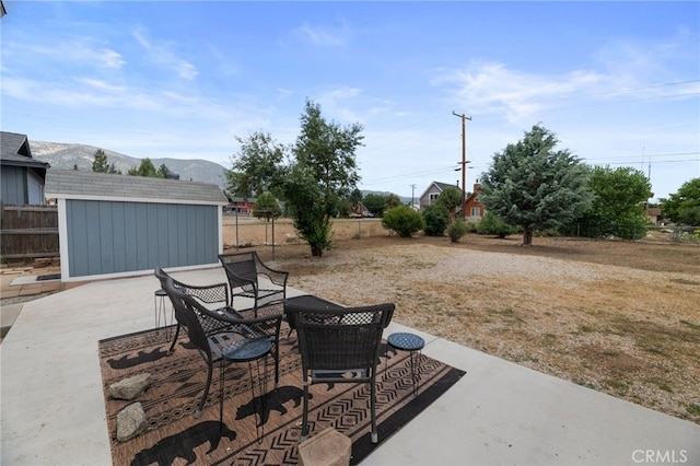 view of patio with a mountain view and a storage unit