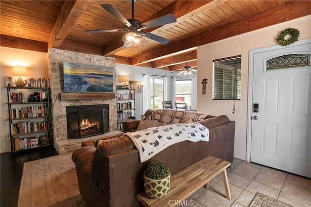 tiled living room featuring a stone fireplace, wood ceiling, and beam ceiling