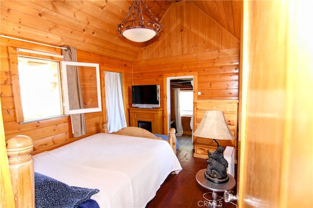 bedroom with vaulted ceiling, wood walls, and dark wood-style flooring