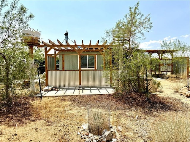 rear view of property featuring a pergola