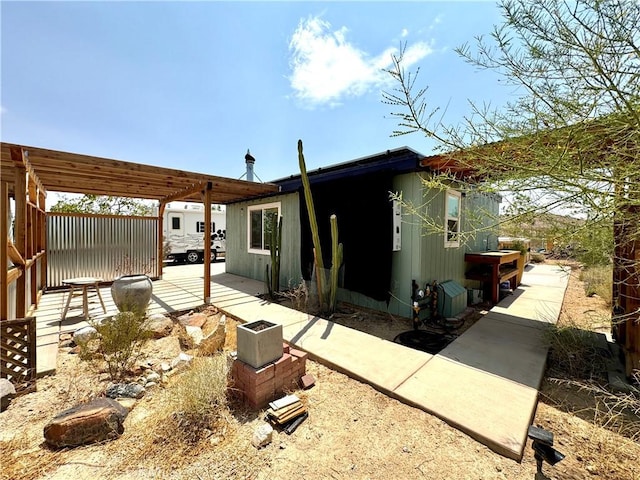 rear view of property featuring a pergola