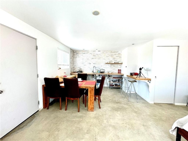 dining room featuring brick wall