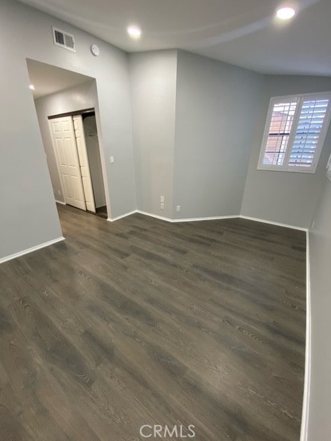 empty room with dark hardwood / wood-style flooring