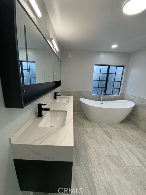 bathroom with a tub, plenty of natural light, and vanity