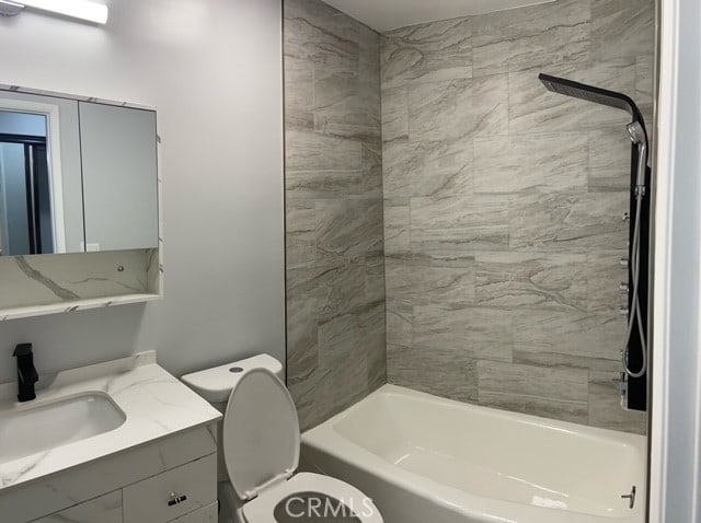 full bathroom featuring vanity, toilet, and tiled shower / bath combo