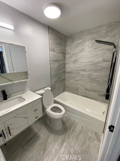 full bathroom with toilet, vanity, and tiled shower / bath