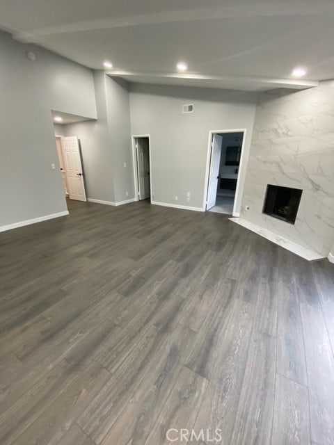 unfurnished living room with dark wood-type flooring and a premium fireplace