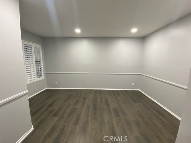 unfurnished room with dark wood-type flooring