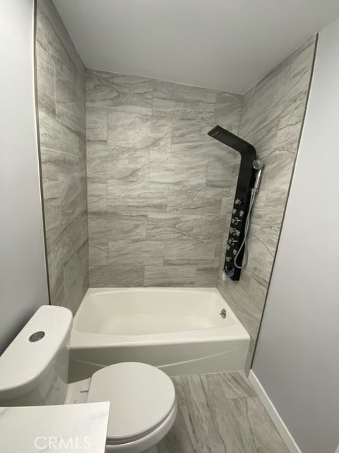 bathroom featuring tiled shower / bath and toilet