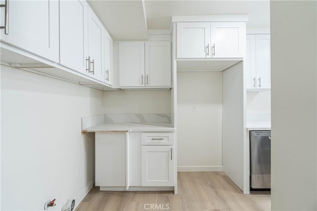 kitchen featuring white cabinets, dishwasher, light stone counters, and light hardwood / wood-style flooring