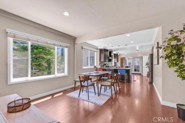 dining room with visible vents, wood finished floors, and baseboards