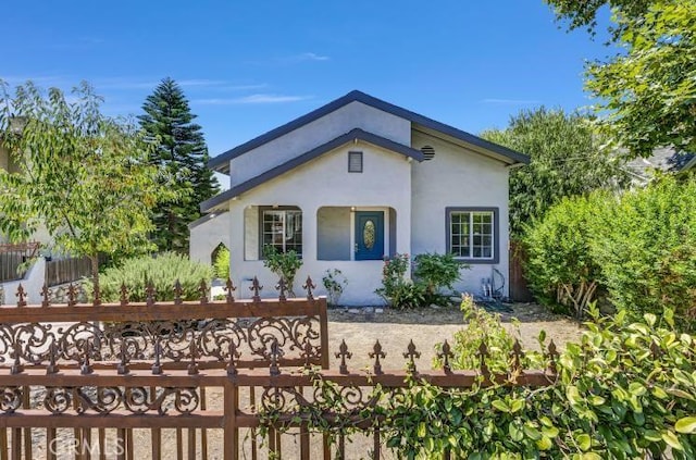 view of front of property with a fenced front yard and stucco siding