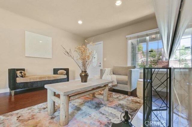 living area featuring recessed lighting, baseboards, and wood finished floors