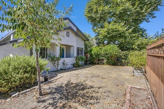 view of home's exterior featuring stucco siding and fence