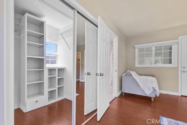 interior space with a closet, baseboards, and dark wood-style flooring