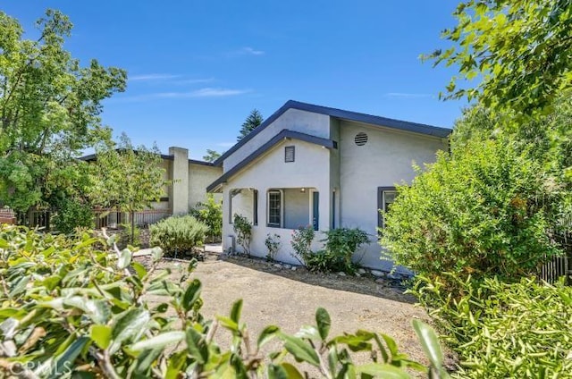 view of front of property featuring stucco siding and fence