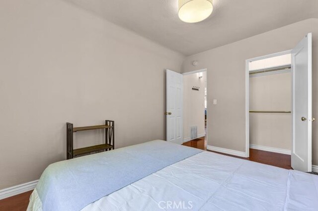 bedroom with a closet, baseboards, and wood finished floors