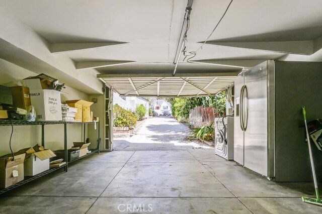 garage with stainless steel refrigerator with ice dispenser