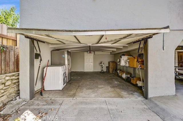 garage featuring washer / dryer and freestanding refrigerator