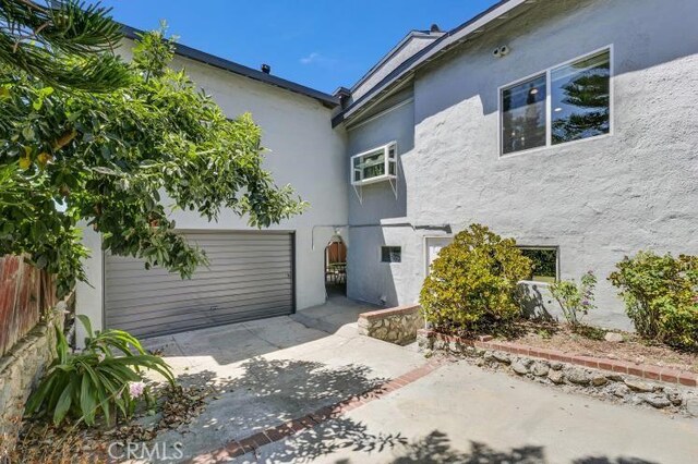 exterior space with a patio area, stucco siding, driveway, and fence