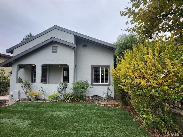 view of front of property featuring stucco siding and a front yard