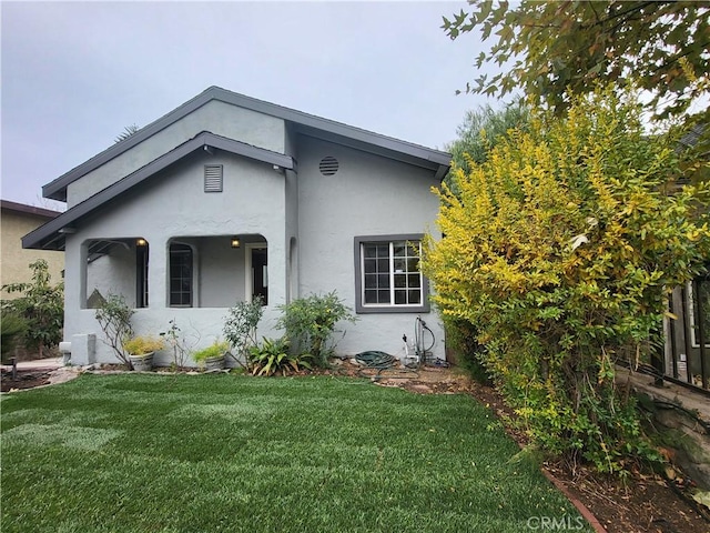 view of front of property with stucco siding and a front lawn