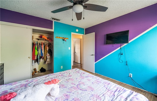 bedroom featuring a closet, ceiling fan, hardwood / wood-style flooring, and a textured ceiling