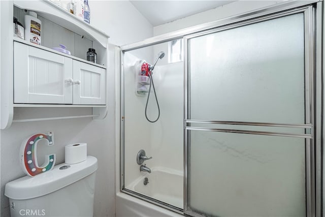 bathroom featuring enclosed tub / shower combo and toilet