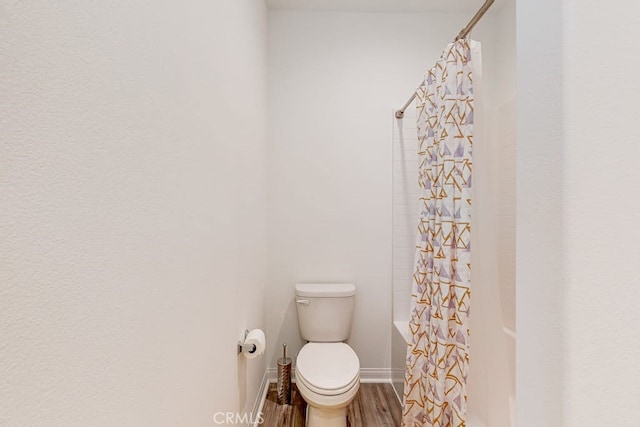 bathroom featuring hardwood / wood-style floors, toilet, and shower / bath combo with shower curtain