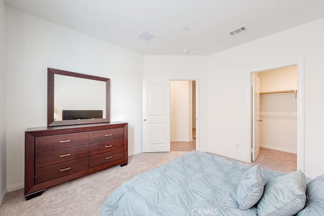 carpeted bedroom featuring a spacious closet and a closet