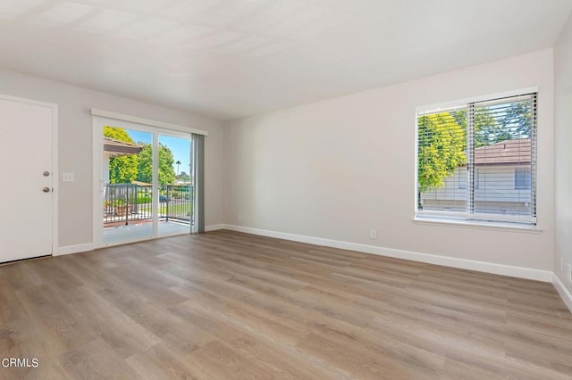 empty room featuring light wood-type flooring and a healthy amount of sunlight