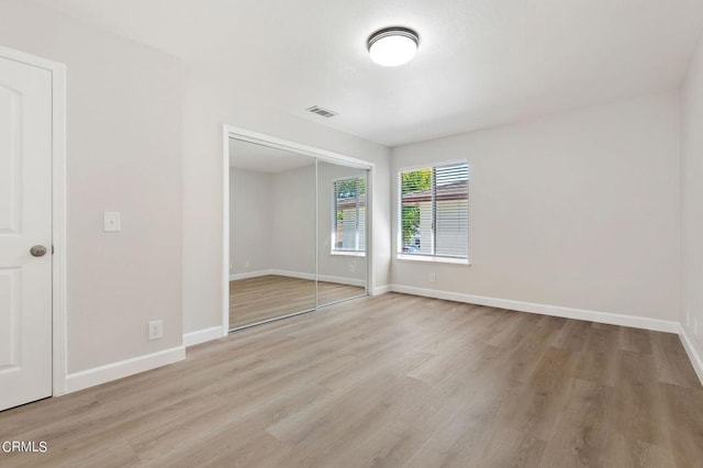 unfurnished bedroom with a closet and light hardwood / wood-style flooring