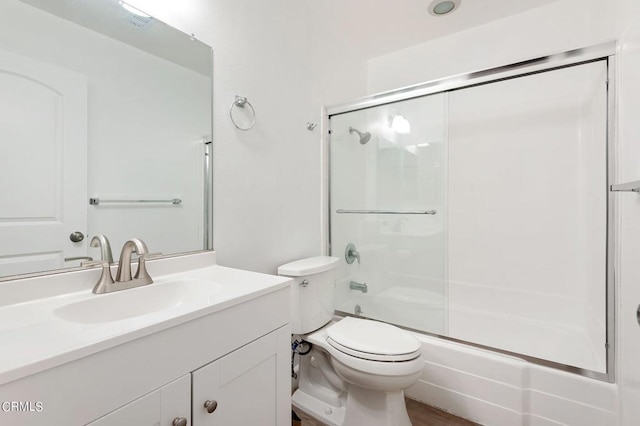 full bathroom featuring enclosed tub / shower combo, vanity, and toilet