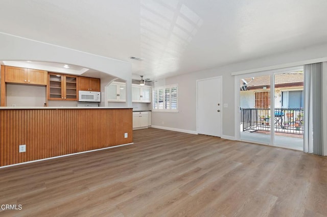 unfurnished living room with ceiling fan and hardwood / wood-style flooring