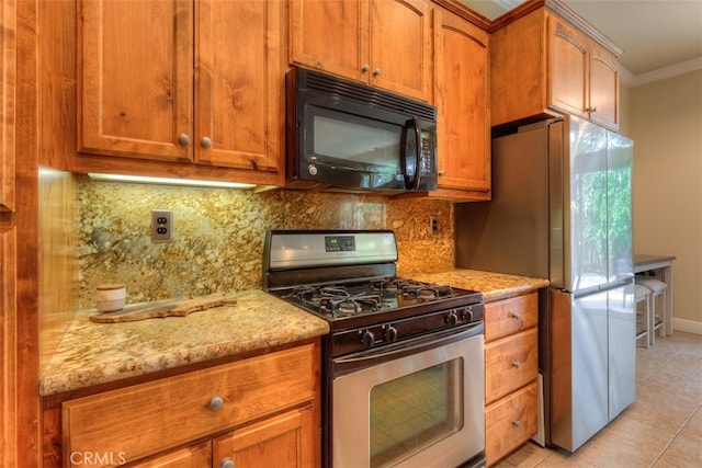 kitchen with tasteful backsplash, light stone countertops, light tile patterned floors, stainless steel appliances, and crown molding