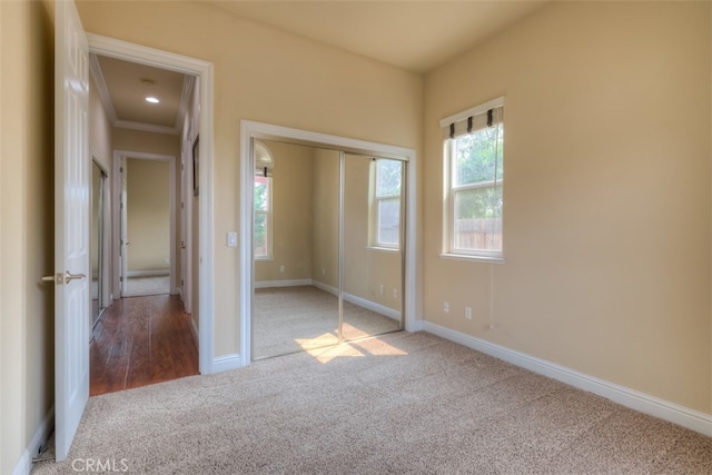 unfurnished bedroom with ornamental molding, a closet, and light hardwood / wood-style floors