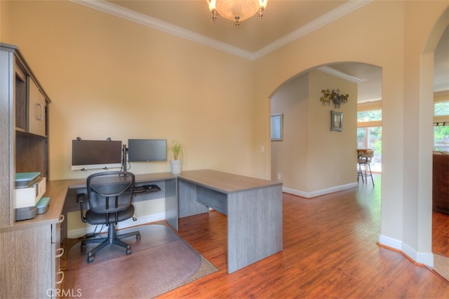 home office featuring built in desk, crown molding, and hardwood / wood-style flooring