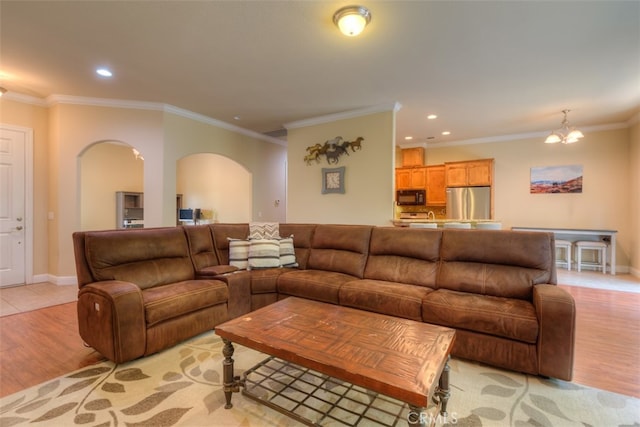 living room featuring light wood-type flooring, crown molding, and a notable chandelier