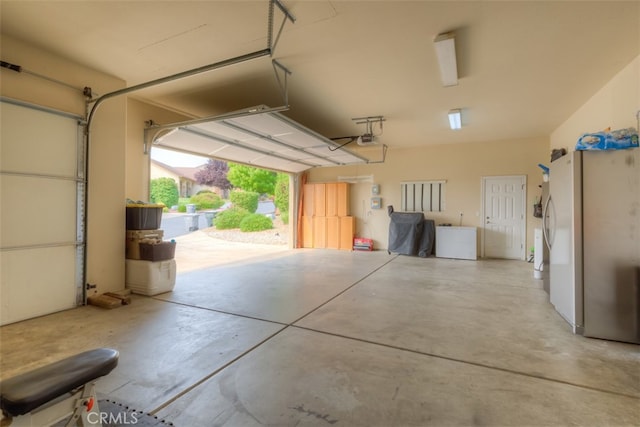 garage with a garage door opener and white fridge