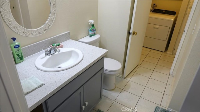 bathroom with vanity, tile patterned flooring, washer / dryer, and toilet