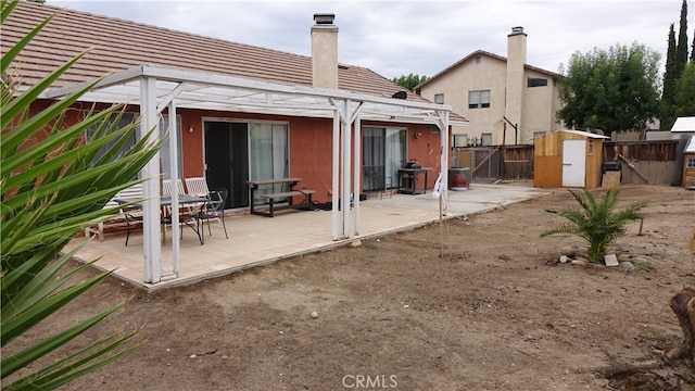 back of property featuring a patio area and a pergola