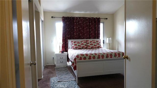 bedroom with multiple windows and dark colored carpet