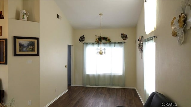 unfurnished dining area featuring high vaulted ceiling and dark hardwood / wood-style flooring