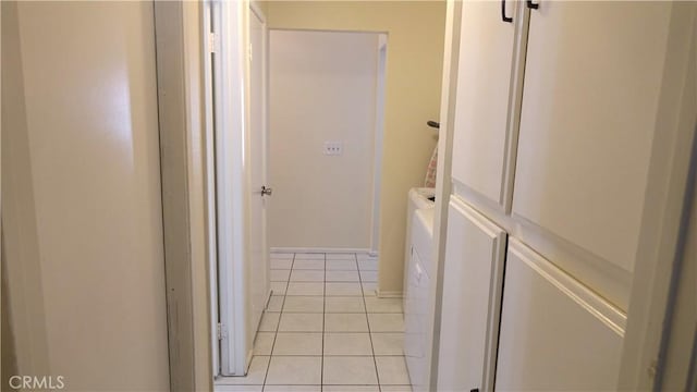 hall featuring washing machine and dryer and light tile patterned flooring