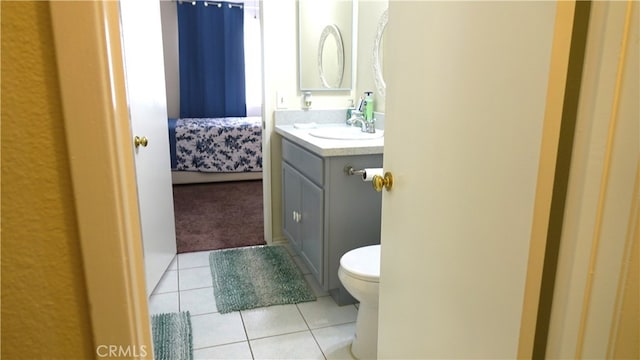 bathroom with tile patterned flooring, vanity, and toilet