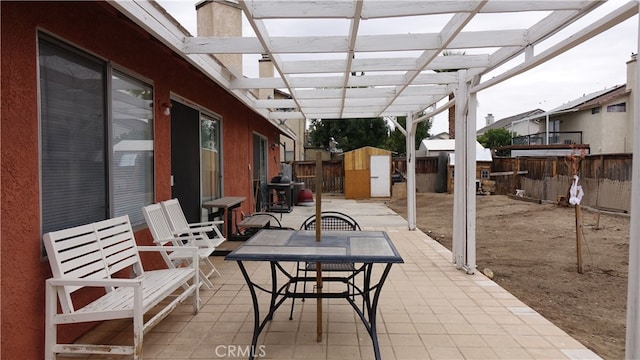 view of patio with a pergola and a storage shed