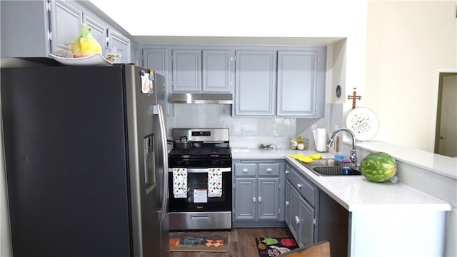 kitchen with gray cabinetry, sink, backsplash, and stainless steel appliances