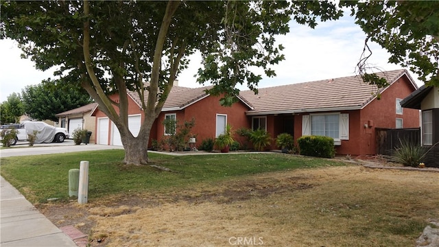 ranch-style house featuring a garage and a front lawn